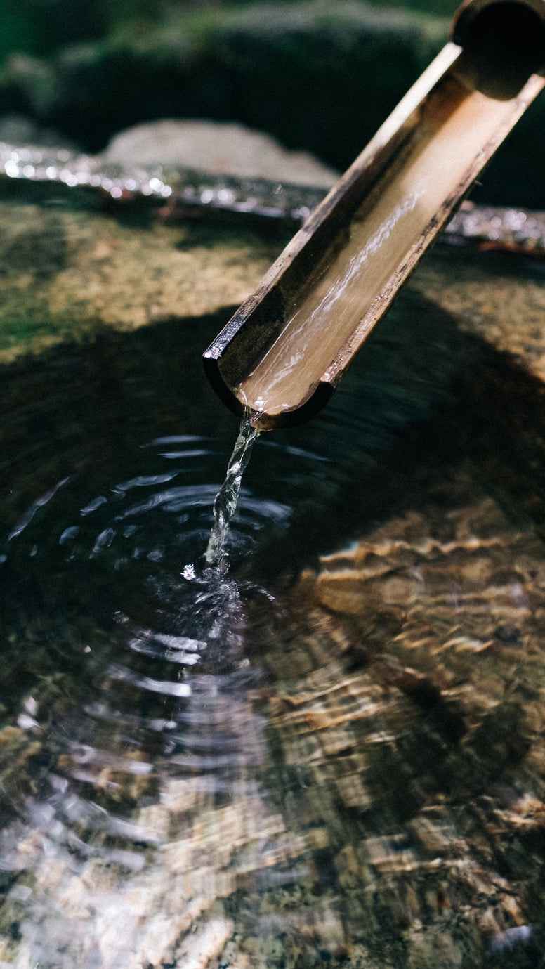 Nahaufnahme eines Bambus-Wasserspiels mit fließendem Wasser
