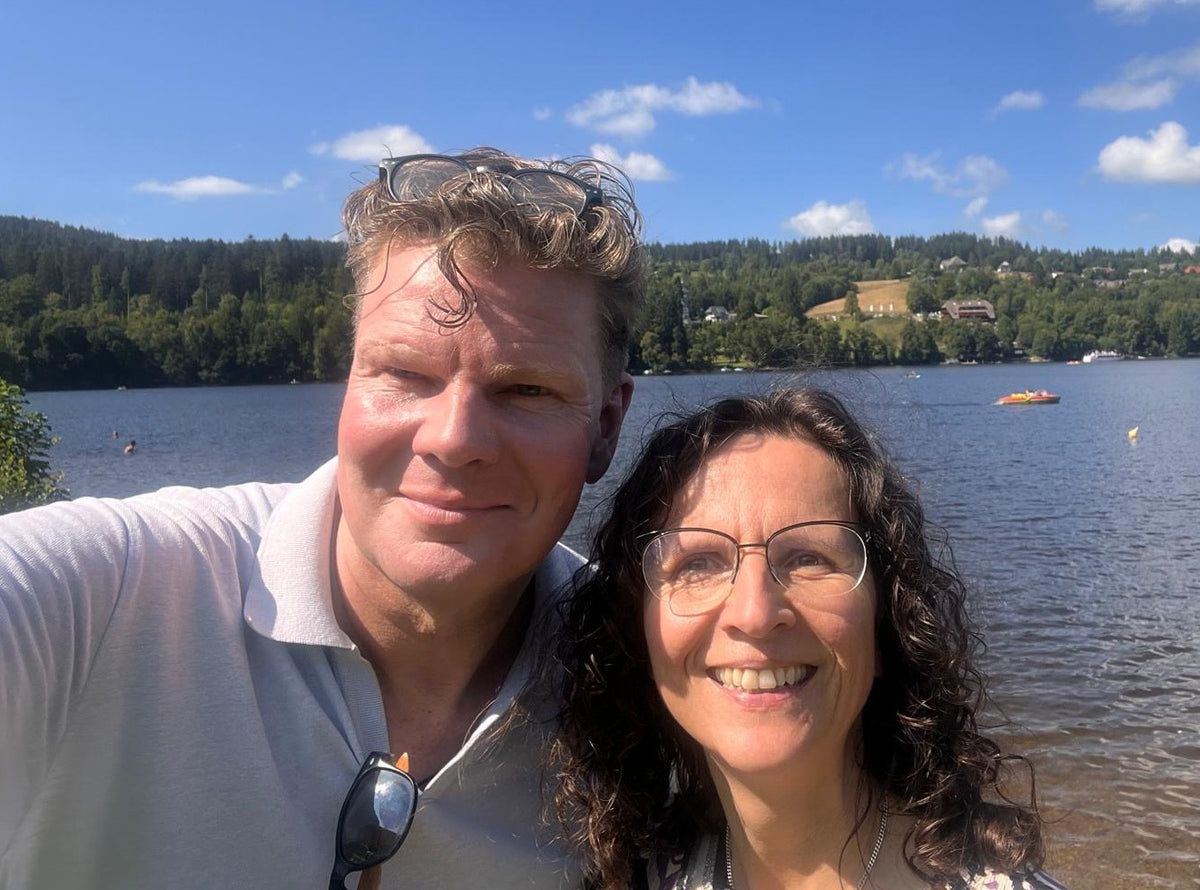 Michaela und Michael vor einer Berg- und Seenlandschaft