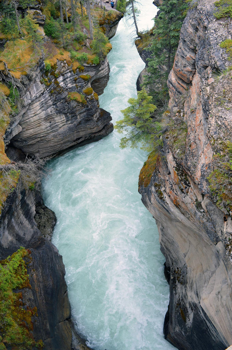 Schnell fließender Weißwasser-Fluss zwischen Felsen in natürlicher Landschaft
